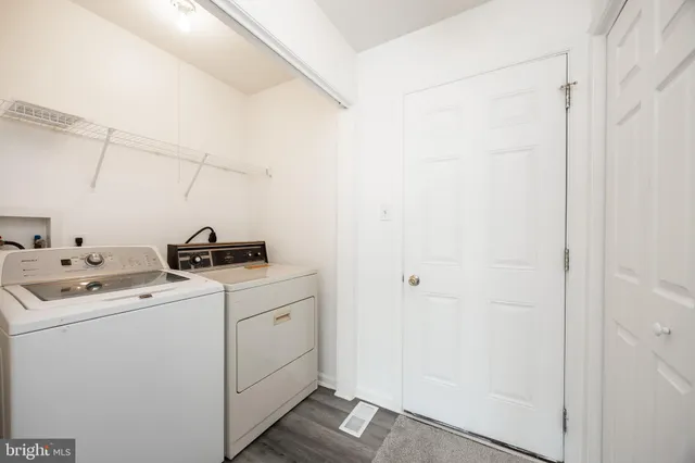 a view of an empty room with window and chandelier fan