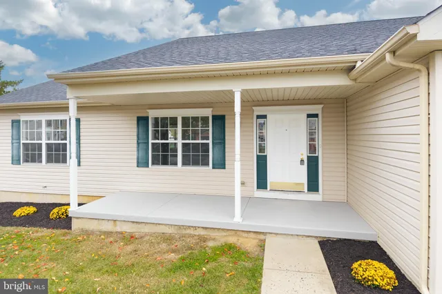 a view of a house next to a big yard with potted plants