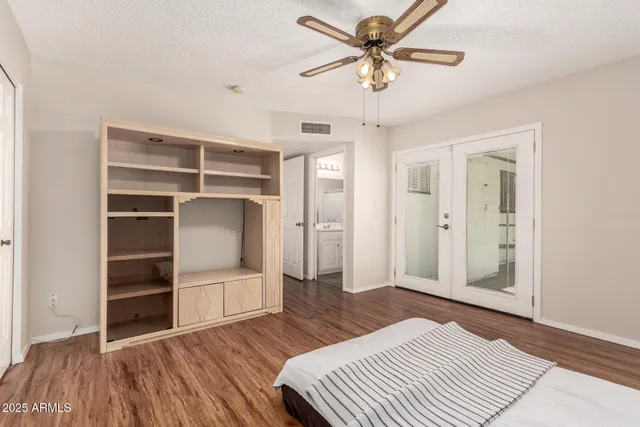 a bedroom with a bed and a chandelier fan