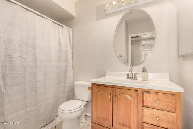 a bathroom with a granite countertop toilet sink and mirror