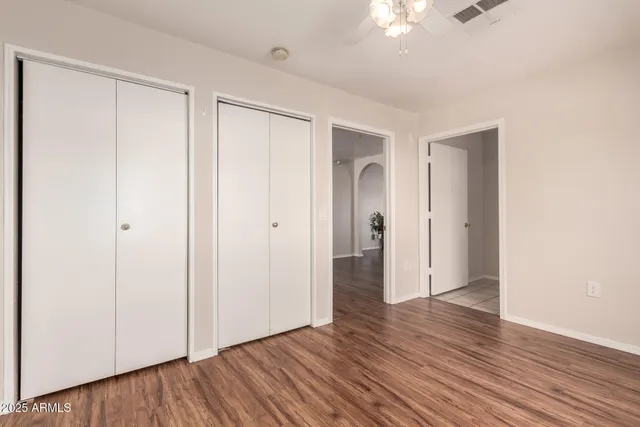 an empty room with wooden floor and closet area