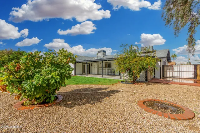 a front view of a house with a yard and a garden