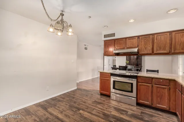 a kitchen with granite countertop wooden floors and stainless steel appliances