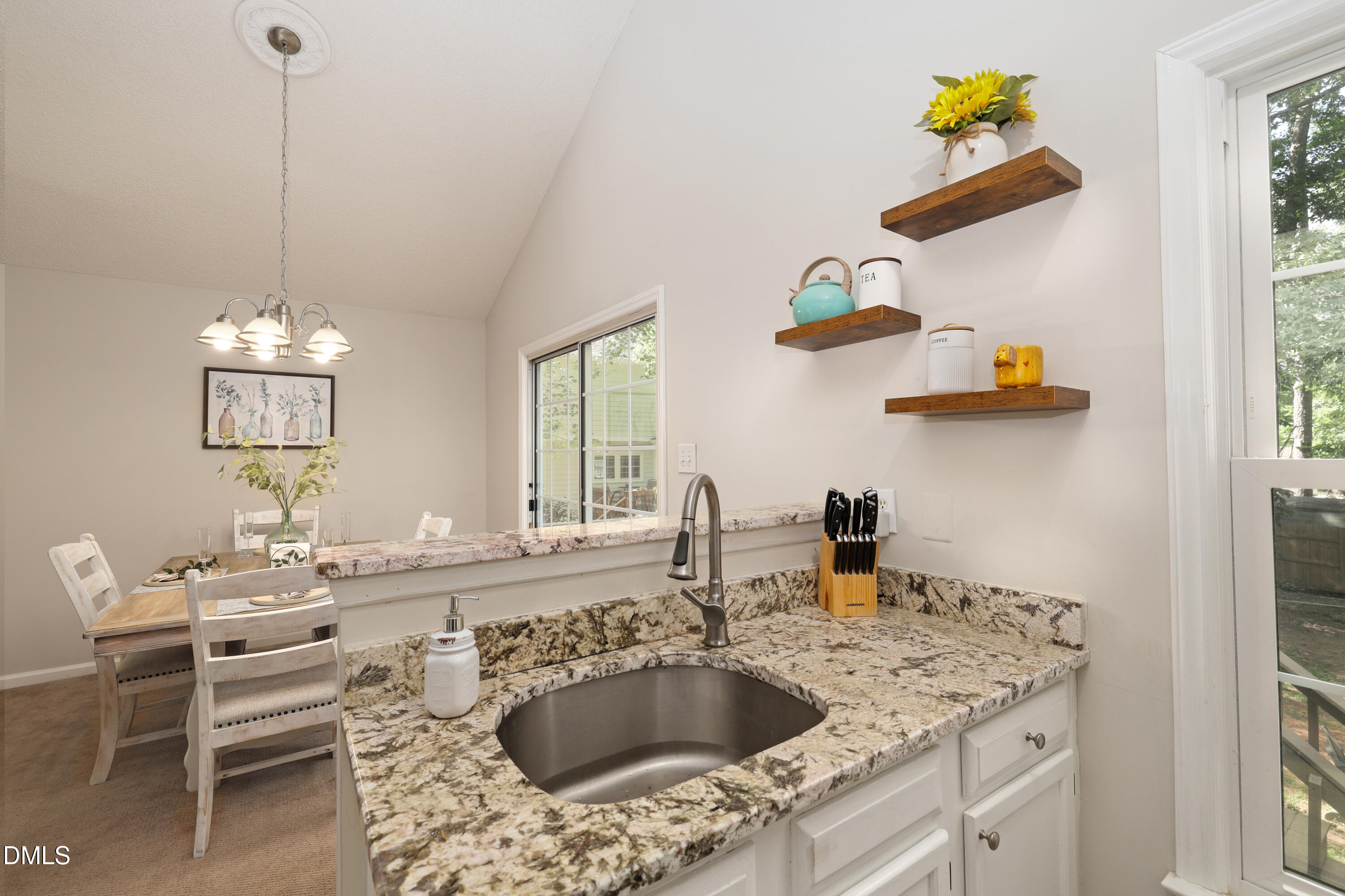 3011 Elk Ridge Road Durham, NC 27712 - Photo 17 of 68 a kitchen with a sink appliances and a dining table