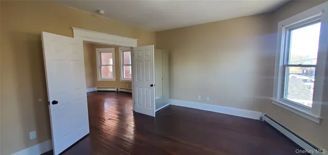 an empty room with wooden floors and windows