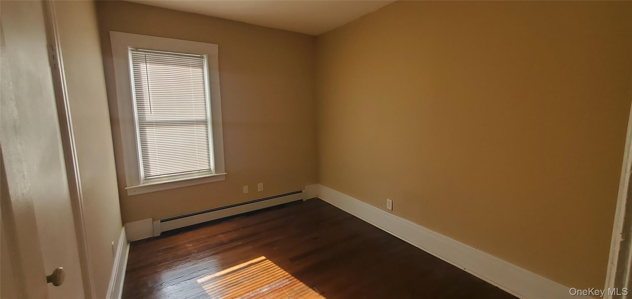 197 Winnikee Avenue, Unit 2 Poughkeepsie, NY 12601 - Photo 19 of 22 an empty room with wooden floor and windows