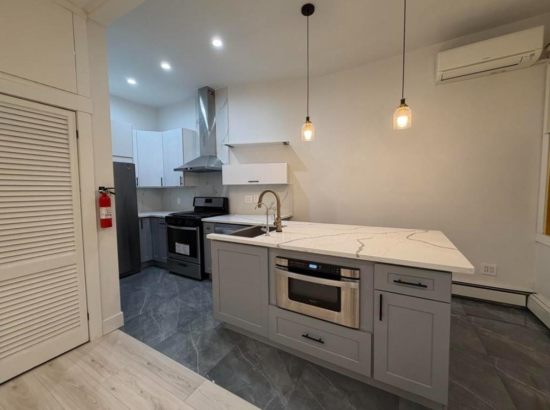 202 48th Street, Unit 3 Union City, NJ 07087 - Photo 2 of 10 a kitchen with stainless steel appliances granite countertop a sink a stove and a refrigerator