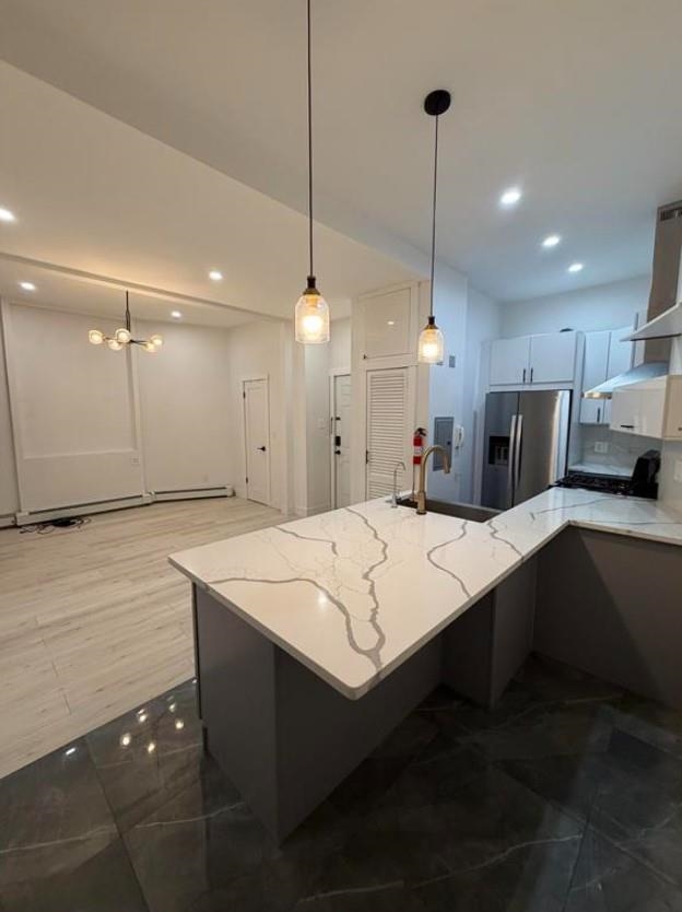 202 48th Street, Unit 3 Union City, NJ 07087 - Photo 9 of 10 a large kitchen with kitchen island a sink stainless steel appliances and chairs