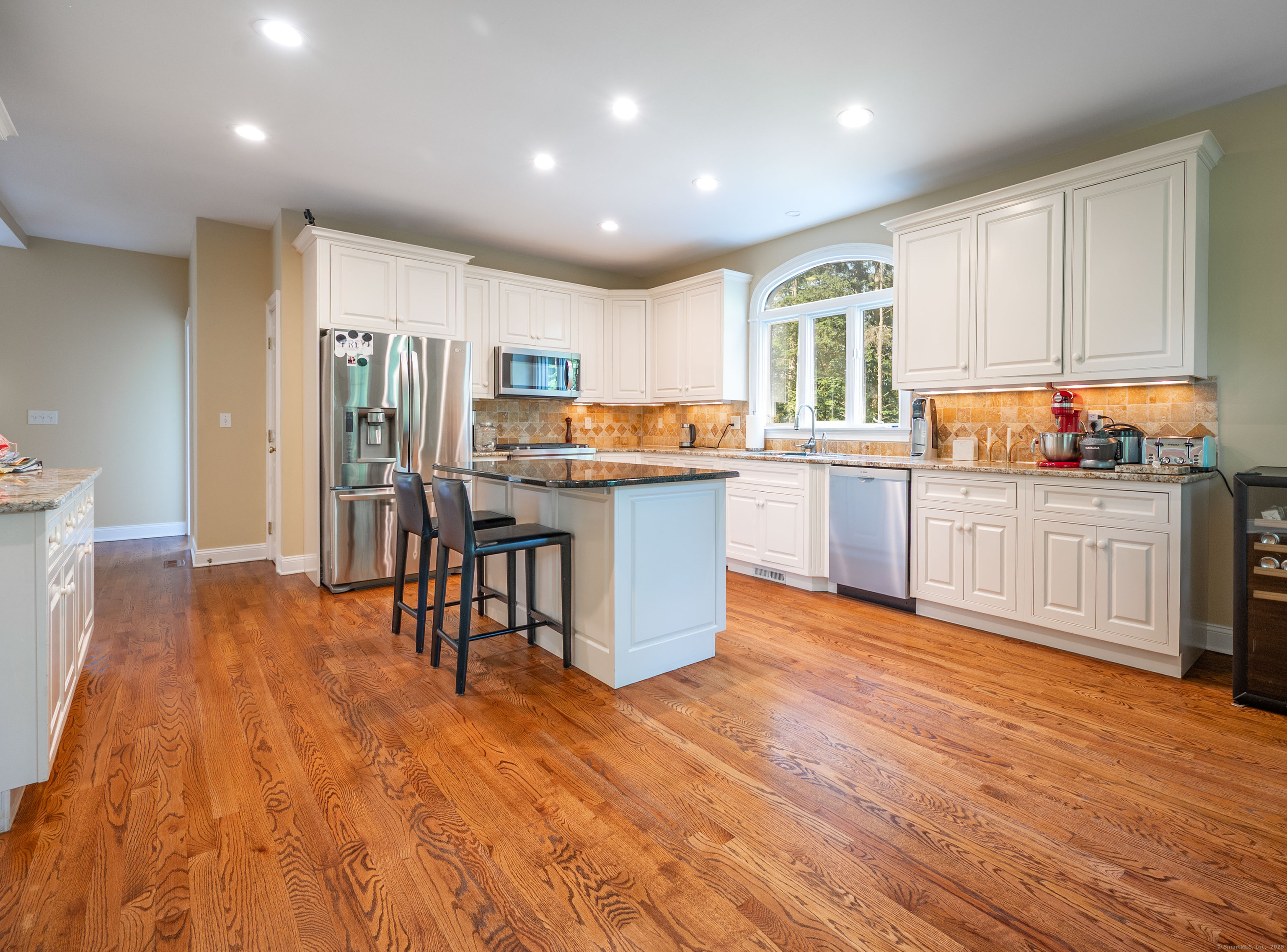 64 River Ford Road Brookfield, CT 06804 - Photo 6 of 28 a kitchen with stainless steel appliances kitchen island granite countertop wooden floors and white cabinets