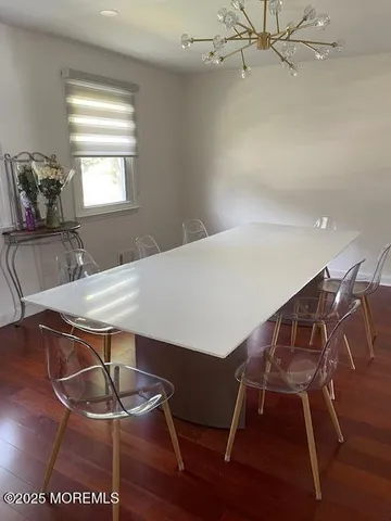 a dining room with wooden floor windows and chairs