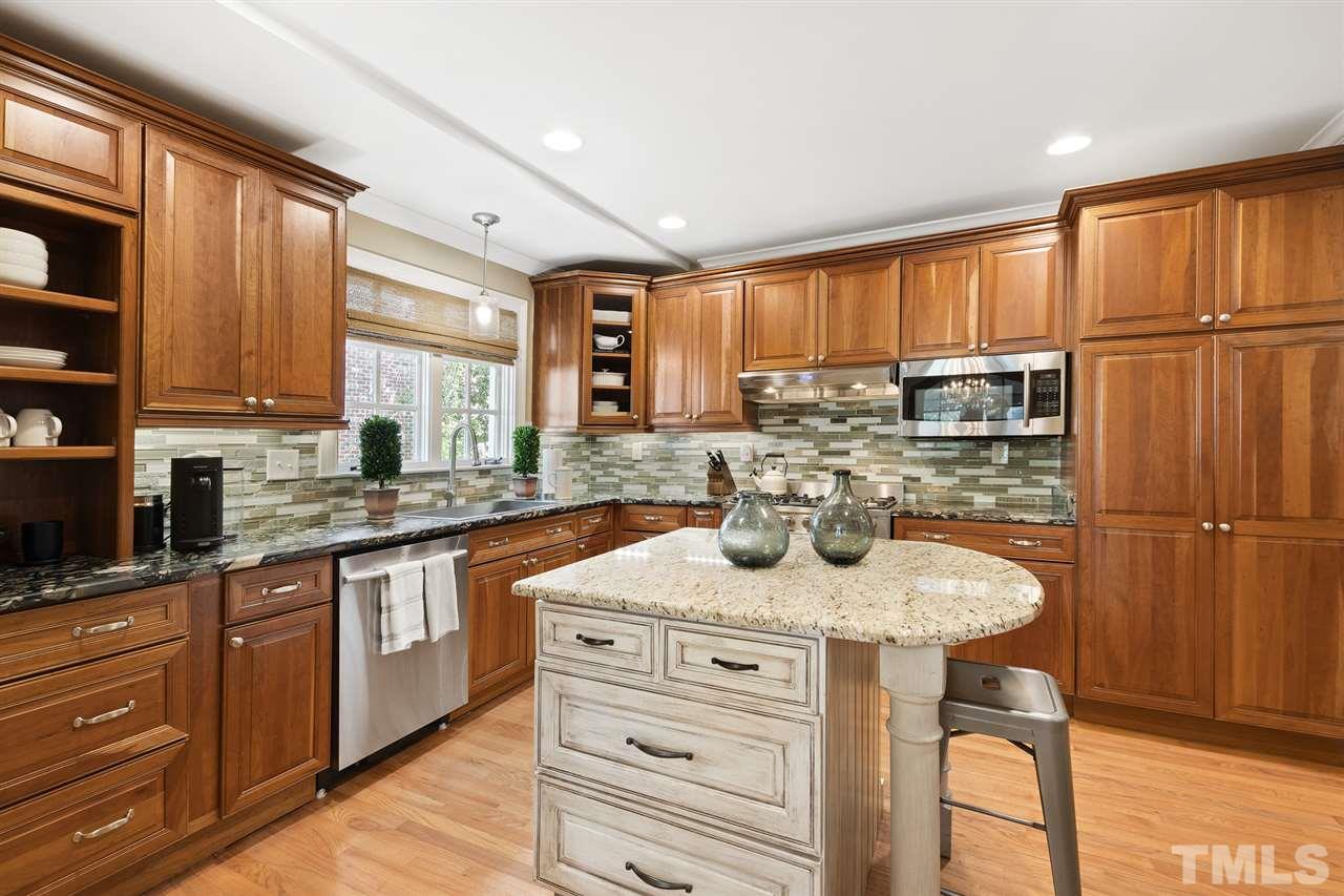 3712 Bellevue Road Raleigh, NC 27609 - Photo 10 of 30 Granite countertops with glass backsplash, spacious center island with granite countertop and storage, Verona 5 gas burner downdraft stovetop with double oven, pantry with lots of storage, Merillat cabinets and drawers with soft close.