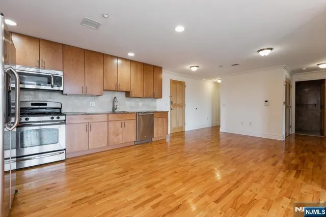 a kitchen with stainless steel appliances granite countertop a stove a sink and a refrigerator