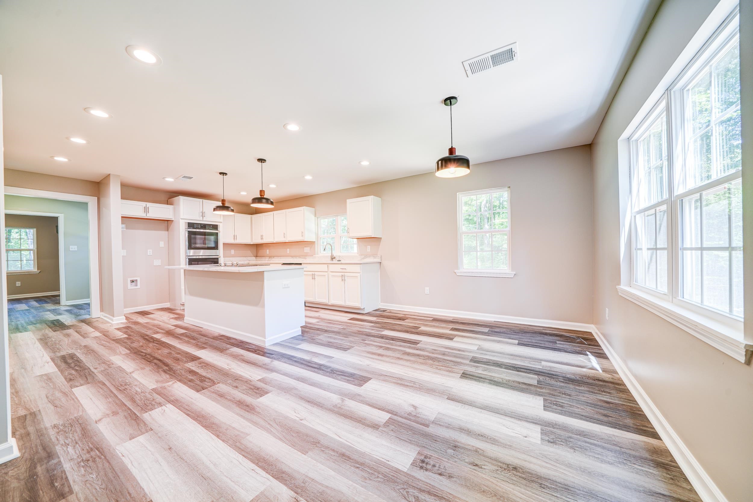 4630 Billy Maher Road Bartlett, TN 38135 - Photo 11 of 40 a view of a kitchen with kitchen island a window wooden floor and a refrigerator