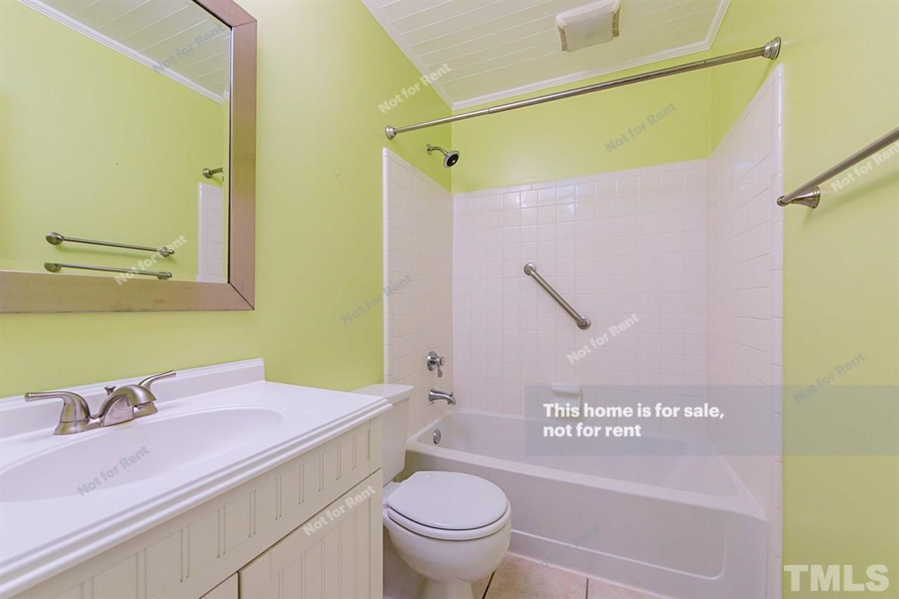 7809 Foxwood Drive Raleigh, NC 27615 - Photo 15 of 17 a bathroom with a granite countertop sink a mirror and a toilet