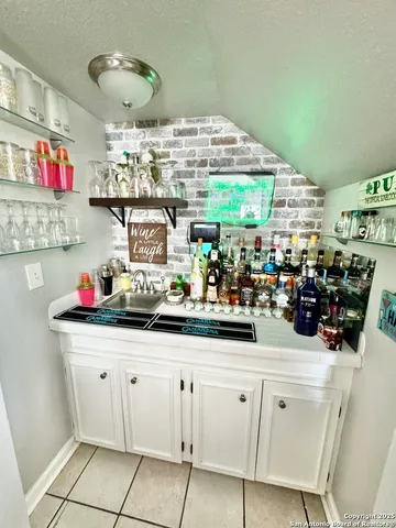 a kitchen with white cabinets and sink