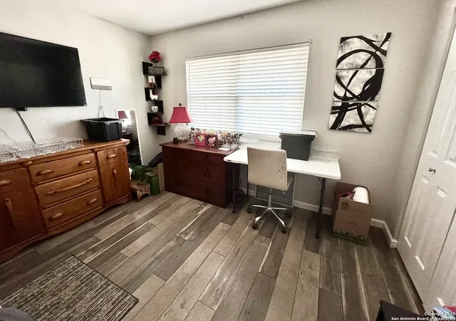 a view of a workspace with furniture and a window