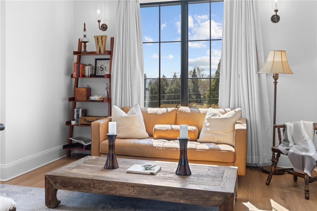 677 Lightwood Road Hartwell, GA 30643 - Photo 22 of 42 This bright living space features hardwood floors, large windows, and wall sconces, creating an inviting atmosphere.