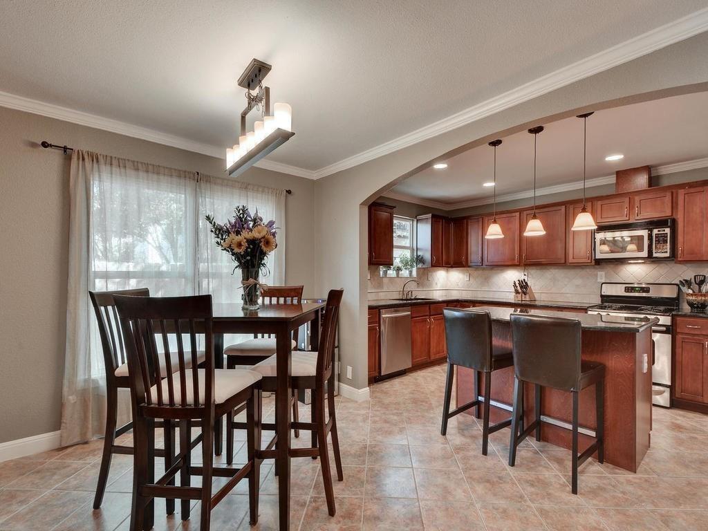 610 West N Loop Boulevard Austin, TX 78751 - Photo 11 of 29 The dining area features tiled flooring, crown molding, and a contemporary chandelier