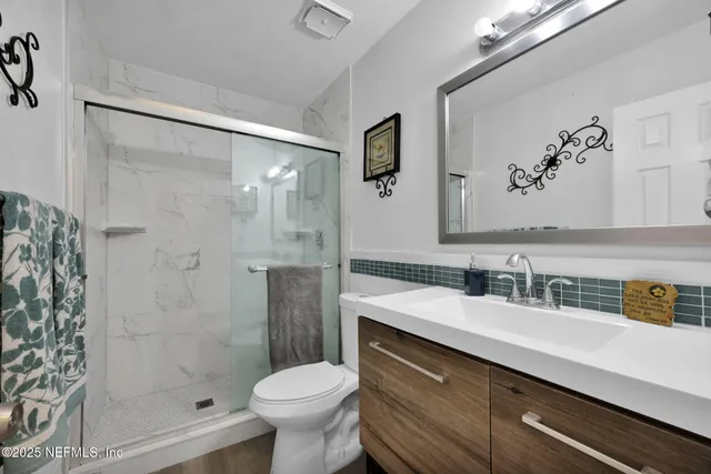 a view of a backyard with lawn chairs under an umbrella