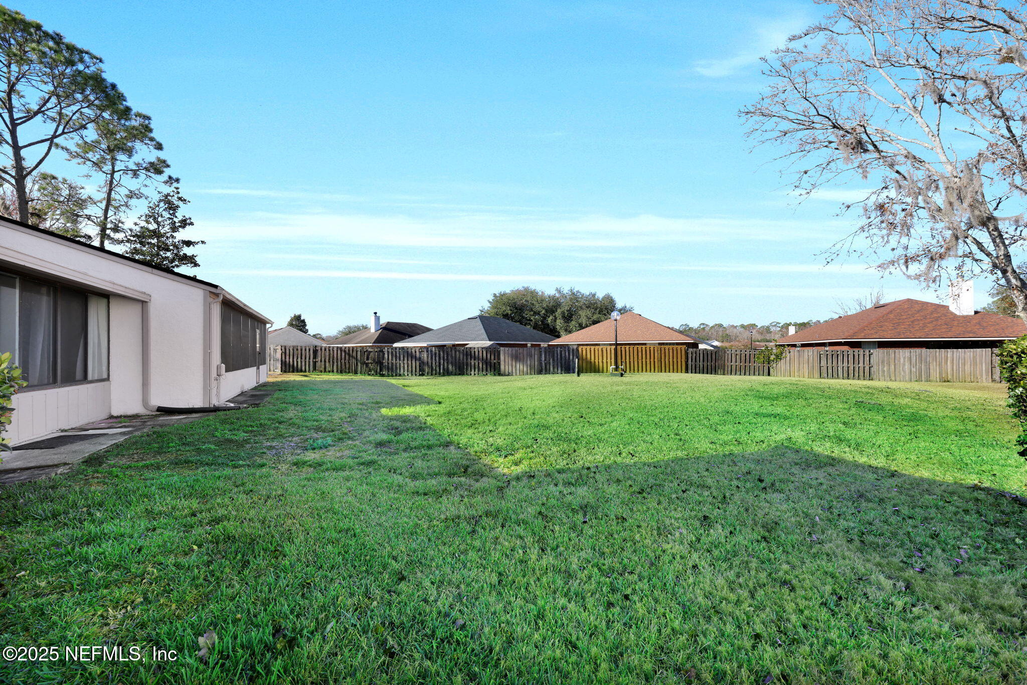 7170 Cypress Cove Road, Unit 28 Jacksonville, FL 32244 - Photo 21 of 22 a view of a backyard with lawn chairs under an umbrella