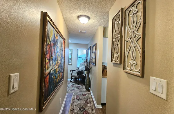 a view of a hallway with wooden floor and stairs