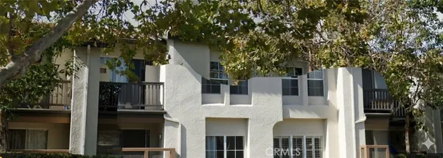a front view of a house with a tree