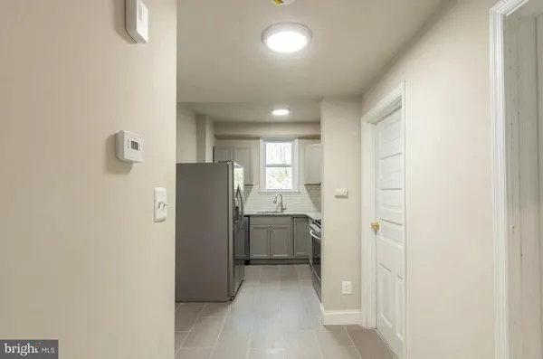 a view of a kitchen with refrigerator and window