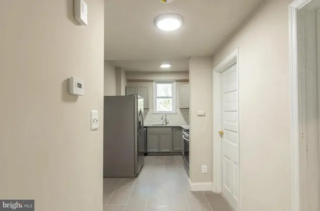 a view of a kitchen with refrigerator and window