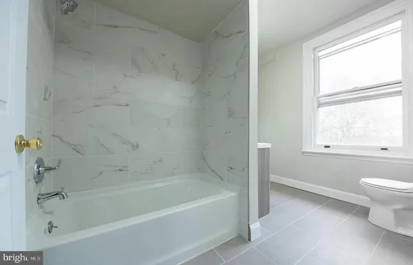 a bathroom with a bathtub and a window