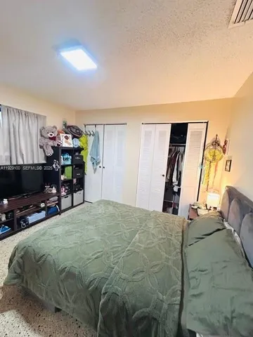 a bed sitting in a bedroom and tv