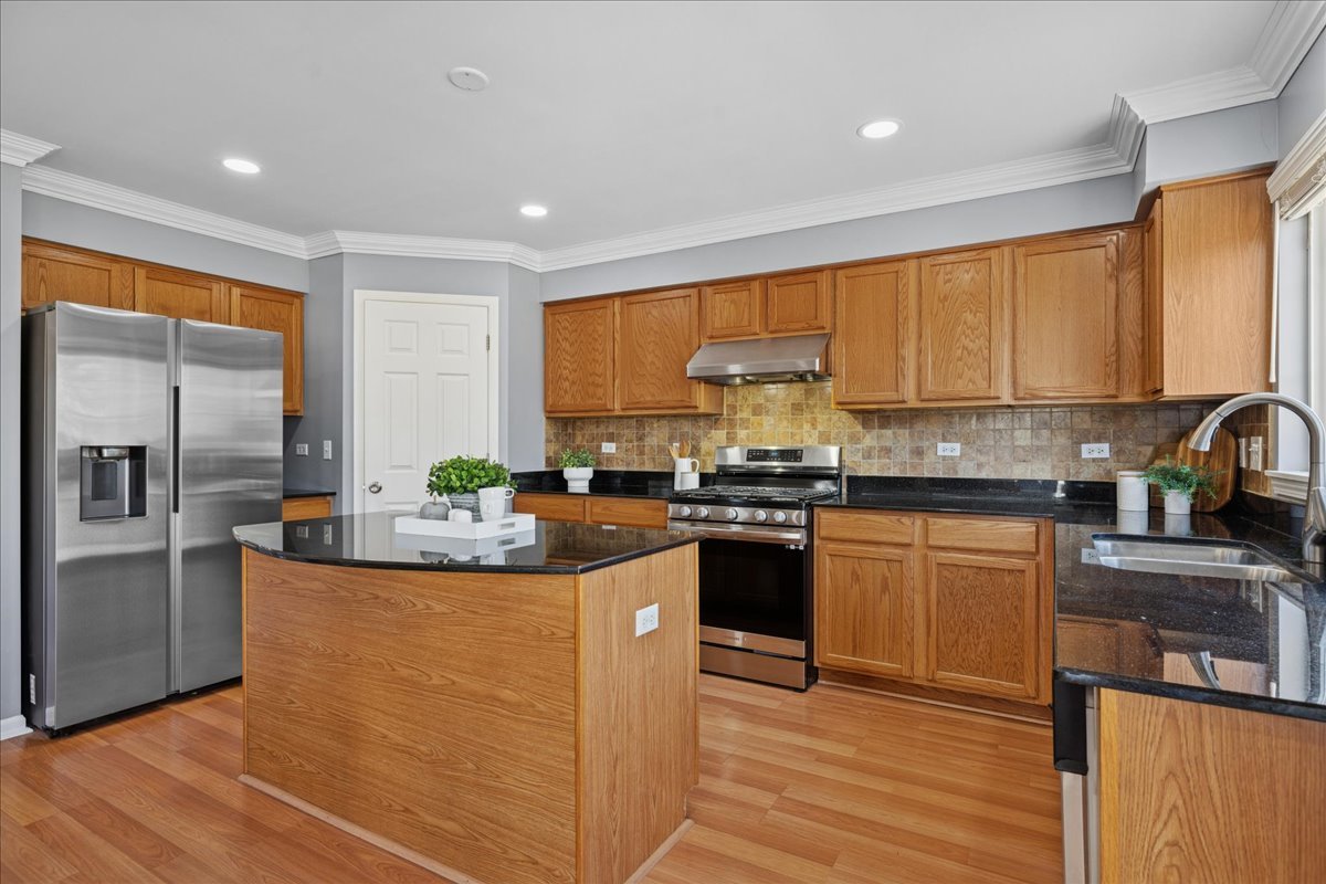1480 Tudor Drive Mundelein, IL 60060 - Photo 9 of 29 a kitchen with stainless steel appliances granite countertop a stove a sink and a refrigerator