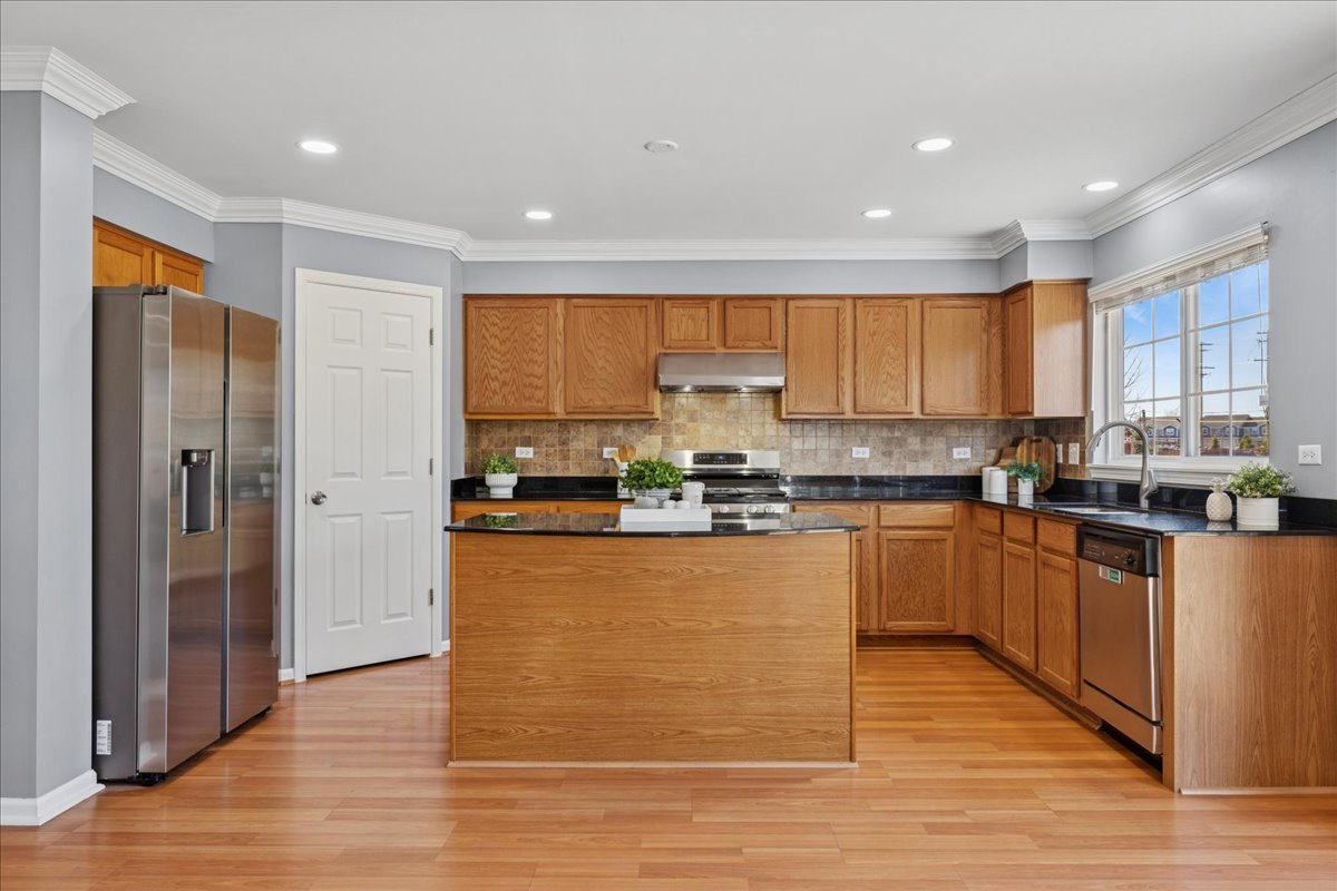 1480 Tudor Drive Mundelein, IL 60060 - Photo 10 of 29 a kitchen with stainless steel appliances granite countertop a refrigerator a sink dishwasher a stove and white countertops with wooden floor