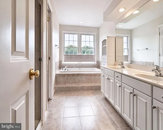 a bathroom with a tub a sink and a large window