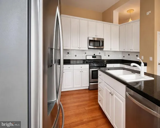a kitchen with stainless steel appliances granite countertop a sink stove and microwave