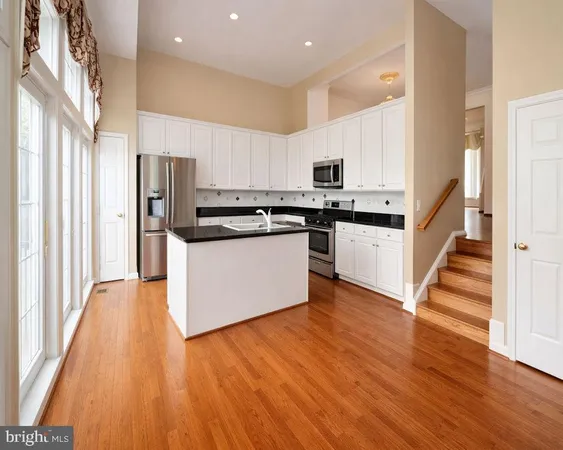 a kitchen with stainless steel appliances a refrigerator and wooden floor