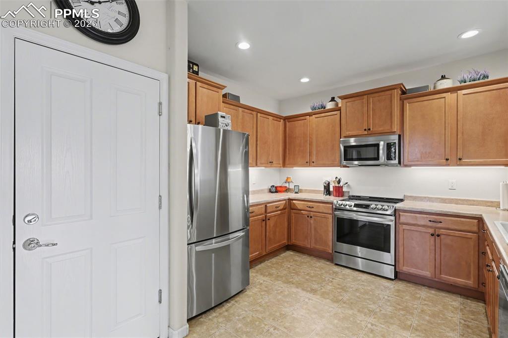 17063 Blue Mist Grove Monument, CO 80132 - Photo 8 of 33 a kitchen with stainless steel appliances granite countertop a refrigerator and a stove top oven