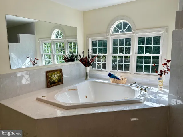 a spacious bedroom with a bed chair and window