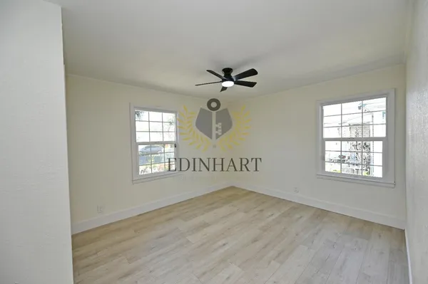 a view of a hallway with wooden floor and entryway