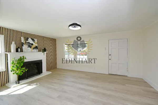 a view of an empty room with a fireplace and a window