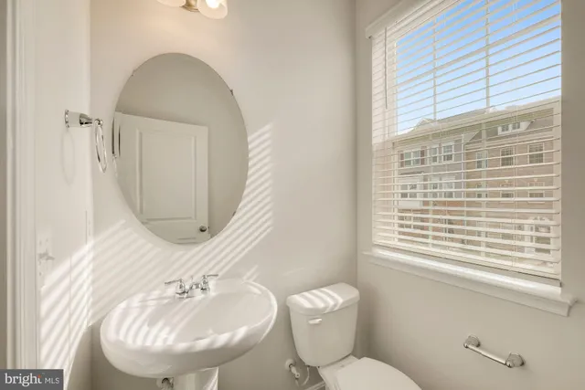 a bathroom with a toilet a sink and a mirror