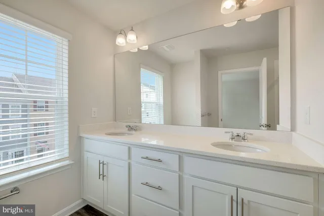 a bathroom with a sink a vanity a lamp and a mirror