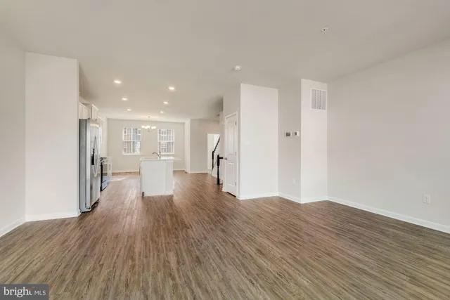 a view of a big room with wooden floor and windows