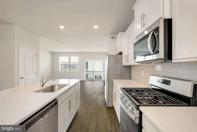 a kitchen with stainless steel appliances granite countertop a stove and a sink