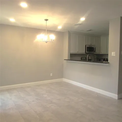a kitchen with granite countertop white cabinets and stainless steel appliances