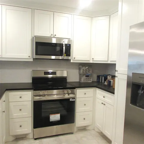 an empty room with a window and chandelier fan
