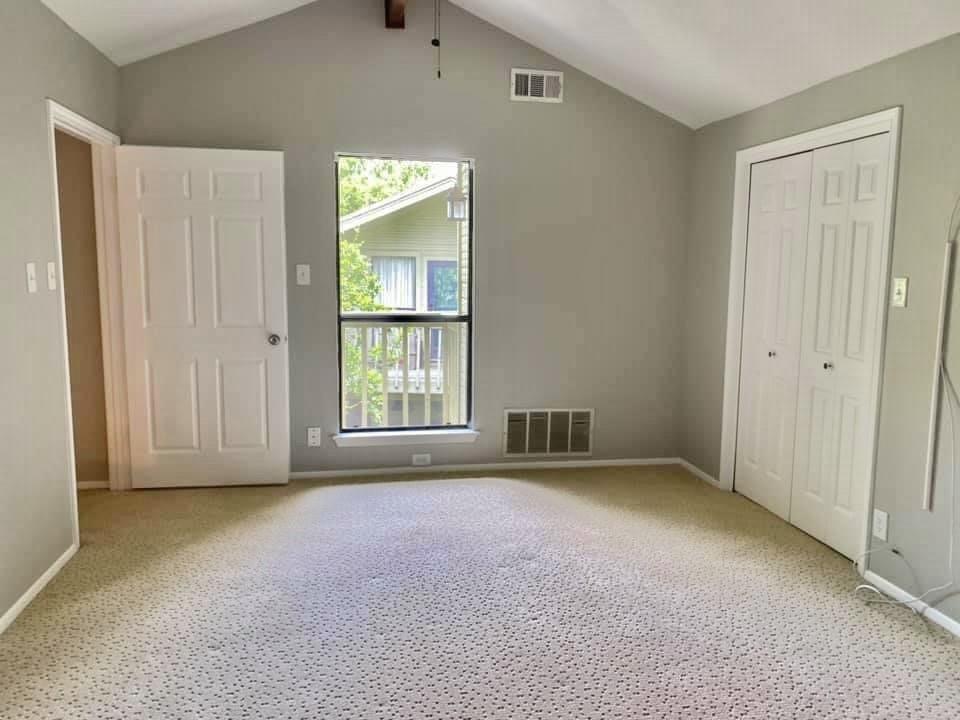 4404 Travis Country Circle, Unit G4 Austin, TX 78735 - Photo 5 of 15 A spacious bedroom features vaulted ceilings and light-toned carpet for a comfortable retreat.