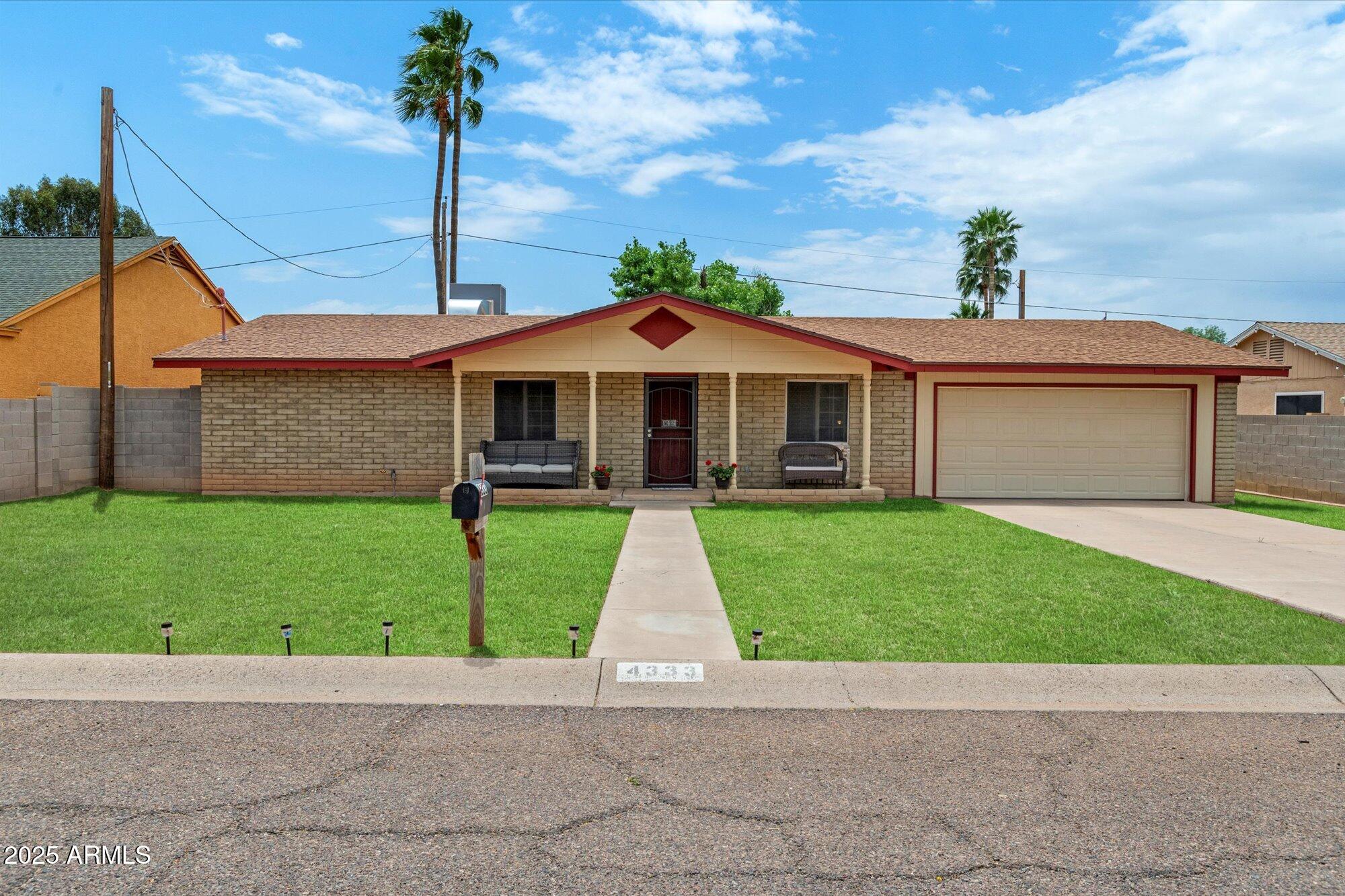 4333 East Desert Cactus Street Phoenix, AZ 85032 - Photo 3 of 18 a front view of a house with a garden and plants