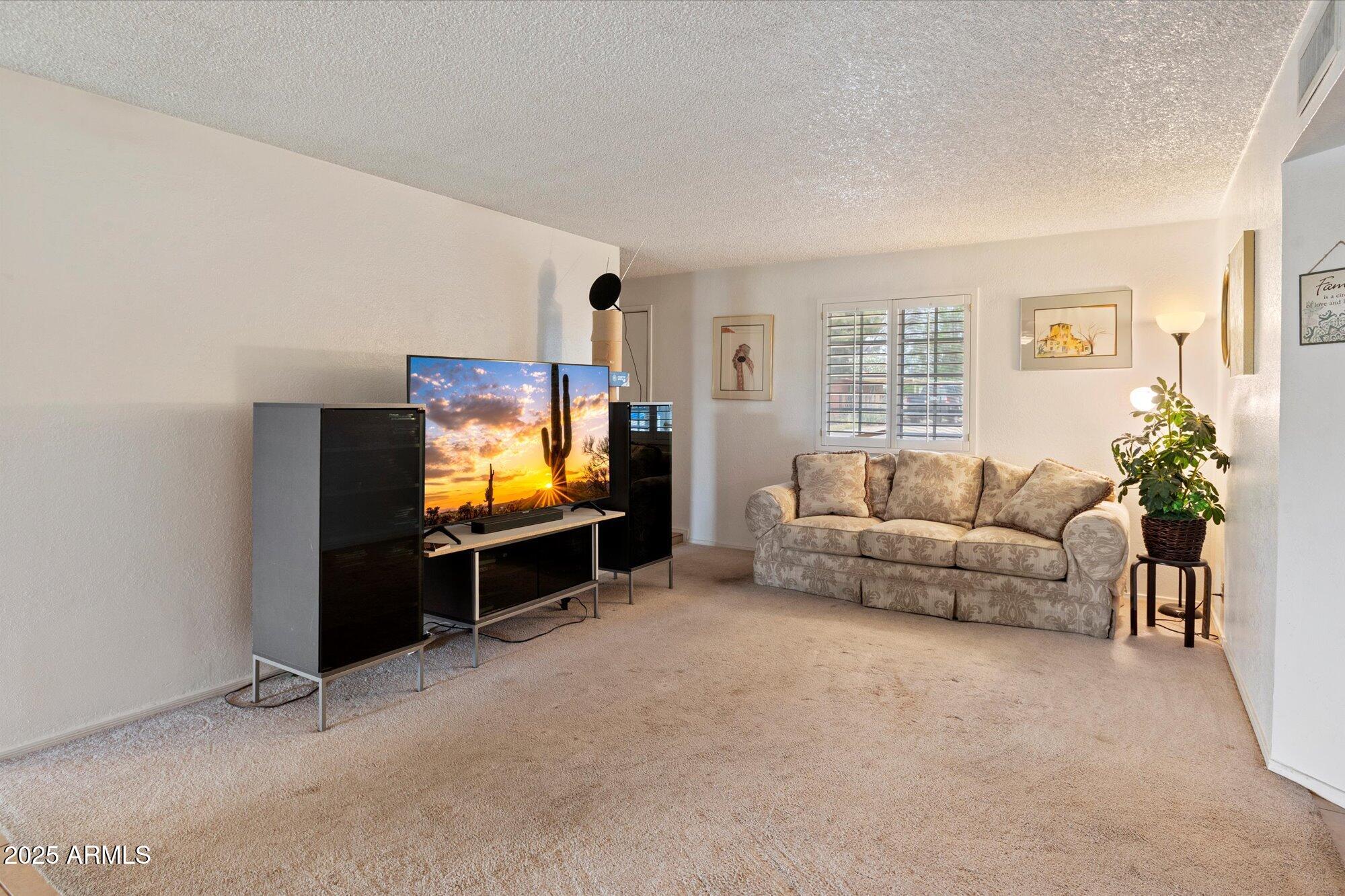 4333 East Desert Cactus Street Phoenix, AZ 85032 - Photo 4 of 18 a living room with furniture and a flat screen tv