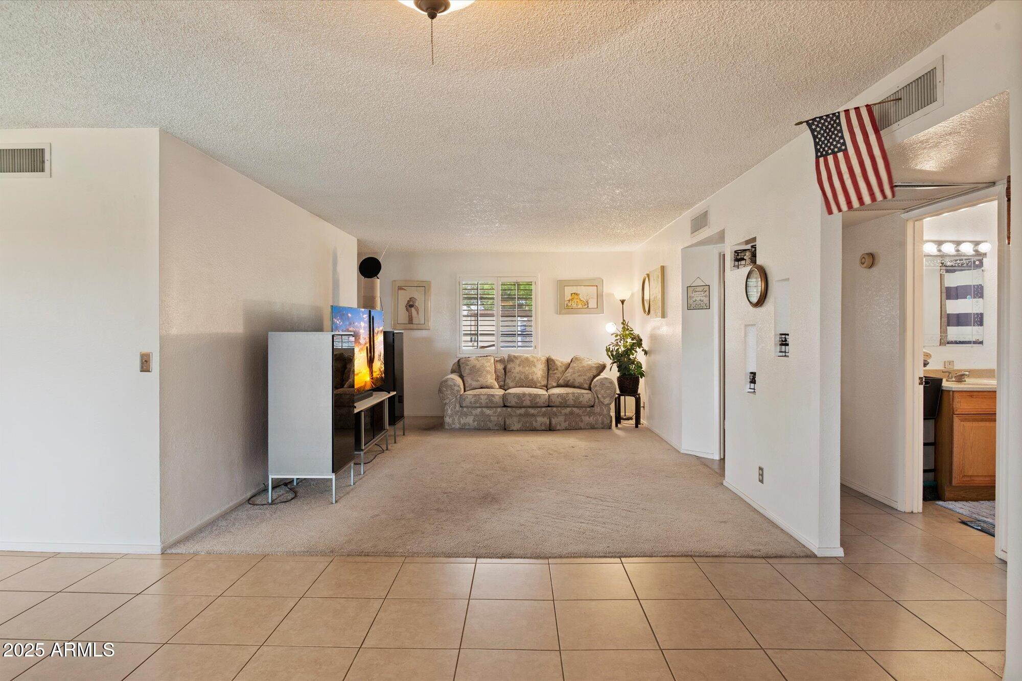 4333 East Desert Cactus Street Phoenix, AZ 85032 - Photo 9 of 18 a living room with furniture and a refrigerator