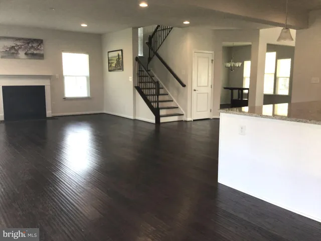 an empty room with wooden floor and staircase